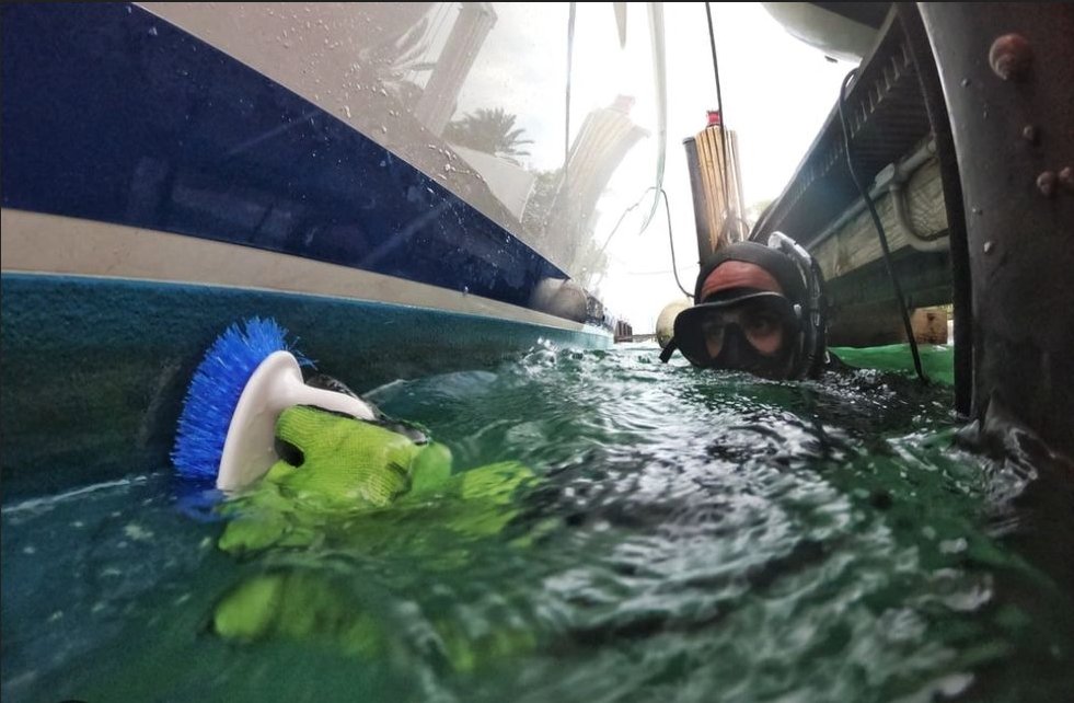 Diver performing underwater hull cleaning with brush